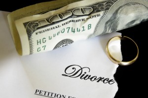 torn divorce decree and cash, with broken wedding ring
