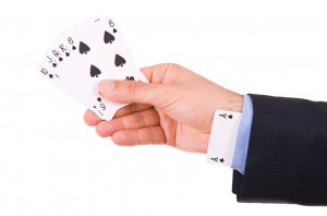 Businessman with ace card hidden under sleeve.