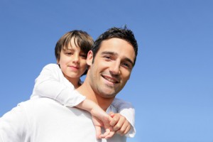 Boy riding piggy back on his father's back